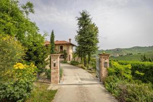 a driveway leading to a house with a gate at Agriturismo Tre Stelle in Barbaresco