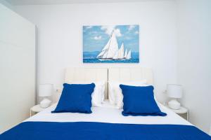 uma cama branca com almofadas azuis e um veleiro em Apartment Zoric em Dubrovnik