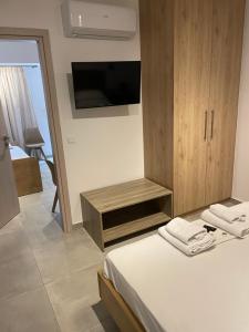 a bedroom with a bed and a cabinet with a tv at Saltriver rooms in Almiropótamos