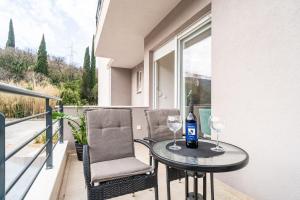 - une table et deux chaises sur un balcon avec des verres à vin dans l'établissement Apartment Zoric, à Dubrovnik