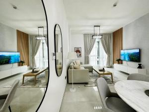 ein Wohnzimmer mit einem Tisch und einem Spiegel in der Unterkunft PR25 - Cozy 1BR in Polo Residences in Dubai