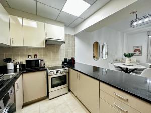 a kitchen with white cabinets and a stove top oven at PR25 - Cozy 1BR in Polo Residences in Dubai