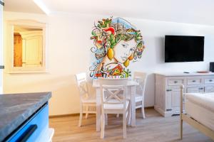 a room with a table with a painting of a woman at H+M Boarding Houses in Lauf an der Pegnitz