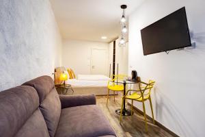 un soggiorno con divano e TV a parete di Arcadia Rooms a Merano