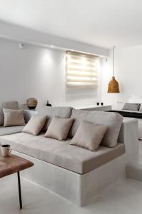 un soggiorno bianco con divano e cuscini di Pebble, Luxury Suite by the Sea a Kokkíni Khánion