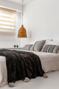 una camera da letto con una coperta nera su un letto di Pebble, Luxury Suite by the Sea a Kokkíni Khánion
