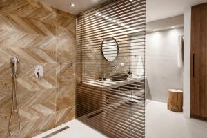 bagno con doccia, lavandino e specchio di Pebble, Luxury Suite by the Sea a Kokkíni Khánion