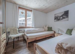 ガシュルンにあるAppartements Rudigierのベッドルーム1室(ベッド1台、椅子、窓付)