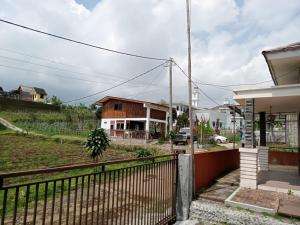 a house with a fence in front of a yard at Homestay Defaza in Lembang