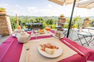 a table with a plate of food and glasses of wine at Agriturismo Tre Stelle in Barbaresco