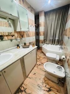 łazienka z umywalką, toaletą i wanną w obiekcie Le Limosine w mieście Napoli