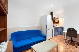 ein blaues Sofa im Wohnzimmer mit Kühlschrank in der Unterkunft Finca Lucrecia in Fasnia