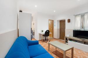 ein Wohnzimmer mit einem blauen Sofa und einem Tisch in der Unterkunft Finca Lucrecia in Fasnia
