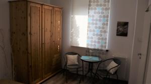 ein Raum mit einem Tisch und Stühlen und einem Holzschrank in der Unterkunft Ferienhaus Primavera in Dornumersiel + 11 Fotos