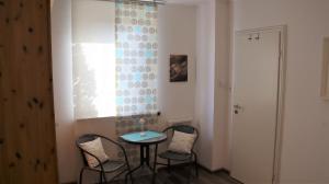 ein Tisch und Stühle in einem Zimmer mit Fenster in der Unterkunft Ferienhaus Primavera in Dornumersiel