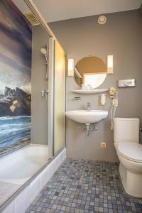 a bathroom with a sink and a toilet and a shower at Fletcher Hotel Restaurant De Witte Raaf in Noordwijk