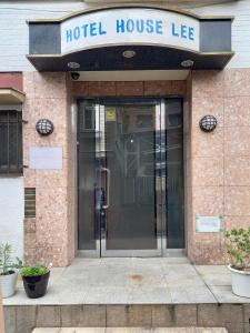 una entrada a una casa de hotel con puerta de cristal en HOTEL HOUSE LEE, en Tokio