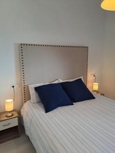 - une chambre avec un grand lit et des oreillers bleus dans l'établissement La casita, à Baños de la Encina