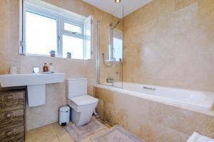 y baño con bañera, aseo y lavamanos. en "Woodlands" by Greenstay Serviced Accommodation - Luxury 3 Bed Cottage In North Wales With Stunning Countryside Views & Parking - Close To Glan Clwyd Hospital - The Perfect Choice for Contractors, Business Travellers, Families and Groups, en Bodelwyddan