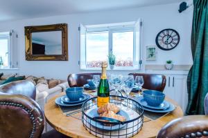 a table with a bottle of wine and wine glasses at "Woodlands" by Greenstay Serviced Accommodation - Luxury 3 Bed Cottage In North Wales With Stunning Countryside Views & Parking - Close To Glan Clwyd Hospital - The Perfect Choice for Contractors, Business Travellers, Families and Groups in Bodelwyddan