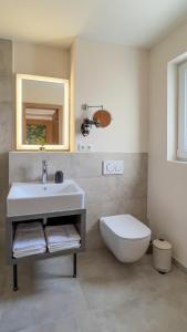 a bathroom with a white sink and a toilet at Hotel fine art in Rotenburg an der Wümme