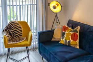 a blue couch and a yellow chair in a living room at Ashview 2 - Heathrow - Thorpe Park - Free Parking in Staines