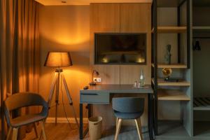 a room with a desk with a lamp and a table and chairs at Hotel fine art UG in Rotenburg an der Wümme
