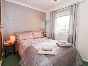 Un dormitorio con una cama con toallas rosas. en Chalet 12 en Great Yarmouth