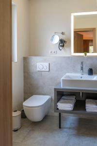Hotel fine art في روتنبورغ أن در فومه: حمام مع حوض ومرحاض ومرآة