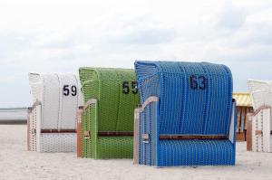 a group of chairs sitting on the beach at Ferienhaus Sunny, FeWo Vermittlung Nordsee in Dangast