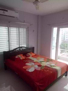 a bedroom with a bed with a red blanket with flowers at 4 Beds Condo Holiday Home at Bashundhara Dhaka in Dhaka