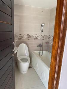 a bathroom with a toilet and a bath tub at 4 Beds Condo Holiday Home at Bashundhara Dhaka in Dhaka