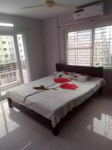 a bedroom with a bed with red flowers on it at 4 Beds Condo Holiday Home at Bashundhara Dhaka in Dhaka