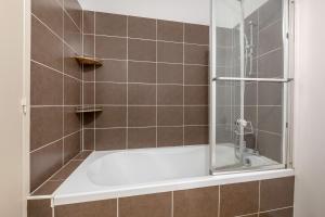 a bathroom with a bath tub with a shower at Appartement a 1km de la mer! in Piriac-sur-Mer