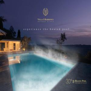 a swimming pool at night with the words wineland interpreting the heated pool at Villa I Barronci Resort & Spa in San Casciano in Val di Pesa