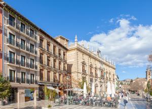 una calle en una ciudad con edificios y gente en Hotel Macià Plaza en Granada