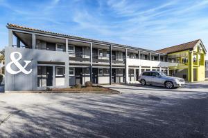 um edifício com um carro estacionado em frente em B&B HOTEL Perpignan Sud Porte d'Espagne em Perpignan