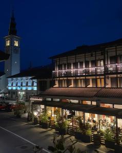 a building with a clock tower in a city at night at Hotel Hvala Superior - Topli Val in Kobarid