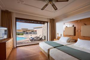 a bedroom with a bed and a view of a pool at Aldemar Olympian Village in Olympia