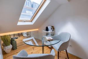 une table en verre et deux chaises dans une chambre avec fenêtre dans l'établissement Condessa IV by Innkeeper, à Lisbonne