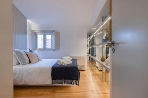 een slaapkamer met een bed met twee handdoeken erop bij Condessa IV by Innkeeper in Lissabon