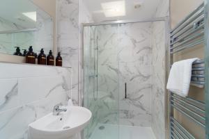 baño blanco con ducha y lavamanos en Apartment One - King Bed - Free Private Parking - by Ocean City Retreats en Plymouth