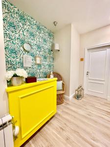 een gele kast in een kamer met een muur bij Twins House Sorrento in Sorrento