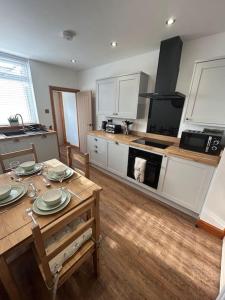 a kitchen with a wooden table with plates on it at Rosy Bay Cottage in Scarborough