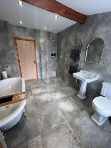 een badkamer met een toilet, een wastafel en een bad bij Rosy Bay Cottage in Scarborough