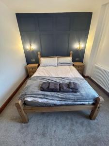 a bedroom with a large bed with a blue headboard at Rosy Bay Cottage in Scarborough