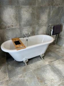 a bath tub with a wooden box on top of it at Rosy Bay Cottage in Scarborough