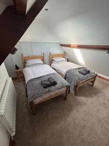 two twin beds in a room with a heater at Rosy Bay Cottage in Scarborough