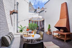 eine Terrasse mit Tisch und Stühlen und einem Sonnenschirm in der Unterkunft Hello I'm Local - Boutique Hostel in Haarlem