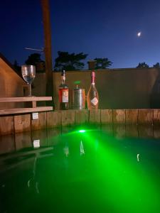 uma piscina de água com garrafas e um copo de vinho em Domki Promyk em Mrzeżyno